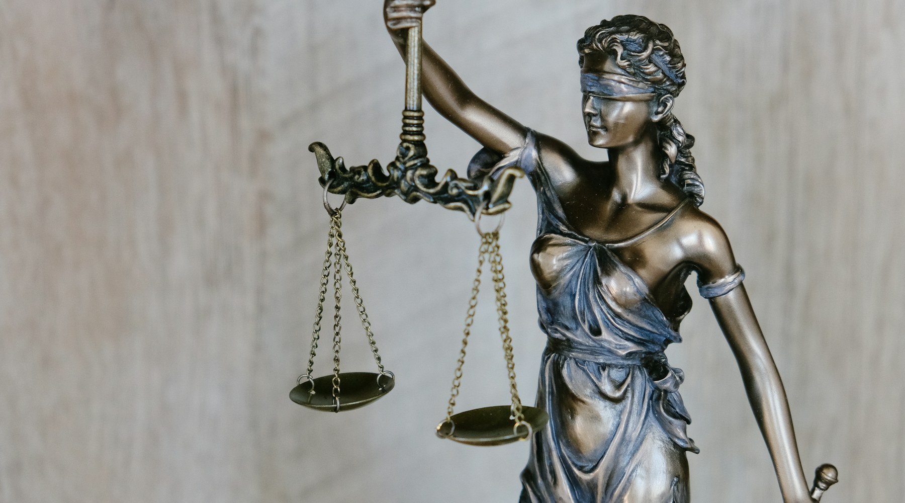Bronze statue of Lady Justice holding balanced scales
